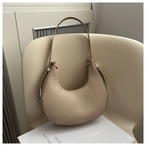 Close-up of beige moon-shaped hobo bag with sleek zipper and silver metal hardware