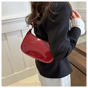 Borsa sottobraccio in vernice rossa lucida con un elegante design curvo per donna