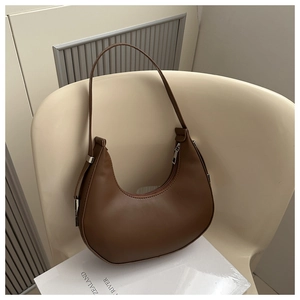 Detail of a dark brown hobo bag featuring smooth matte leather and silver metal zippers