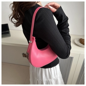 Detail view of pink crescent hobo bag worn by model with silver metal buckle