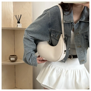 Detailed view of cream PU leather hobo bag with adjustable strap on a shoulder