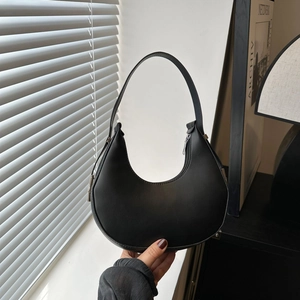 Sleek black faux leather saddle bag with minimalist crescent shape and top handle design