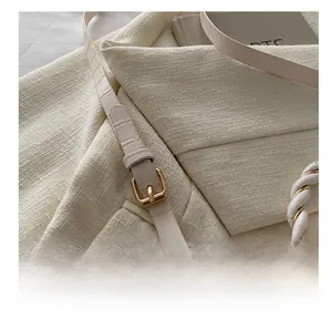 Detailed macro view of white crocodile pattern strap with adjustable gold metal buckle