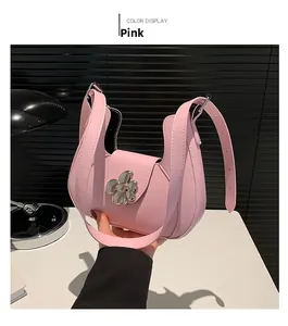 Détail du sac selle en cuir mat rose avec fermoir fleur argenté et bandoulière réglable