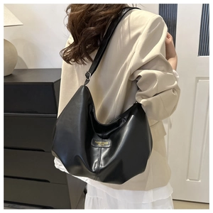 Détail du grand sac hobo noir avec bandoulière réglable et boucle en métal argenté brillant