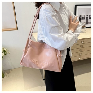 Detail view of pink tote bag with embossed lettering and side decorative knots