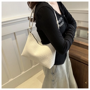 Détail du sac à bandoulière tressé blanc avec texture carrée et bandoulière fine