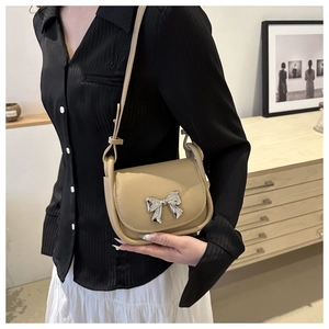 Détail du sac selle en cuir PU kaki avec un nœud en métal argenté élégant et une bandoulière