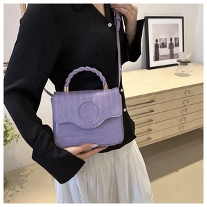 Detail of light purple crocodile texture handbag with unique twisted woven handle