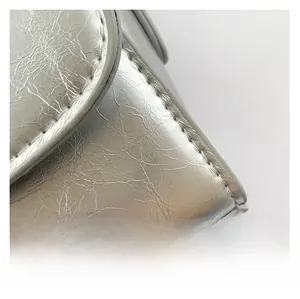 Macro shot of silver textured synthetic leather with metallic finish and fine stitching
