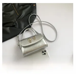 Silver bow mini square bag with metallic crinkled leather compared to an iPhone