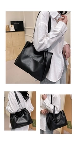 Detail of black tote bag with silver chain straps and decorative cross stitching