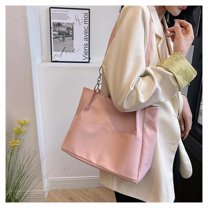 Detailed view of a pink PU tote bag featuring front dual pockets and metal chain strap