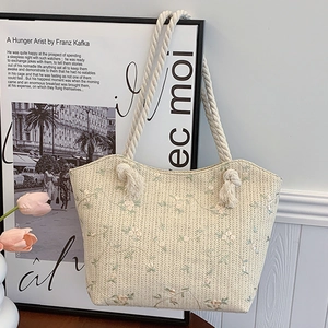 Chic beige straw tote bag with delicate floral embroidery and rope handles for women