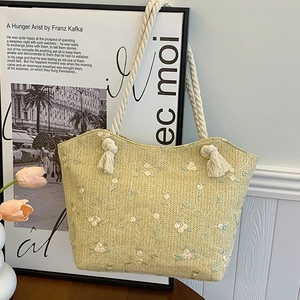 Straw woven tote bag with blue and white floral embroidery and hemp rope handles