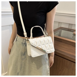 Detailed view of white quilted PU leather handbag with golden hardware and top handle