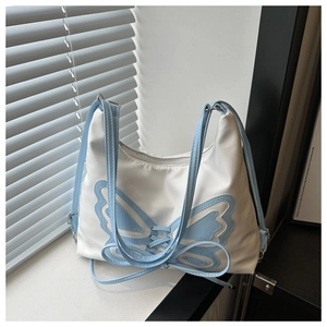 Detail of white bucket bag featuring blue butterfly applique and stylish drawstring design