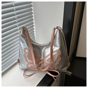 Detail of silver metallic shoulder bag with pink butterfly embroidery and ribbon laces