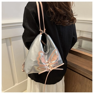 Detailed close-up of a silver bucket bag featuring pink butterfly embroidery and ribbon