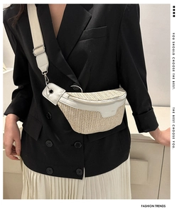 Dettaglio di un marsupio in paglia intrecciata beige con patta in pelle bianca e tracolla