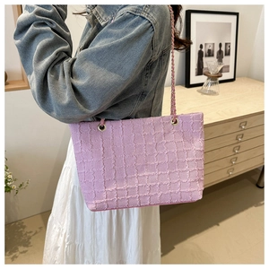 Détail du sac cabas à carreaux lilas avec bords effilochés et bandoulière en chaîne