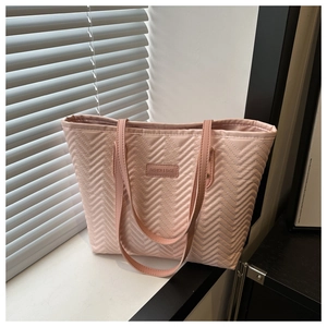 Dettaglio della borsa tote trapuntata rosa chiaro con trama a onde e logo sul davanzale