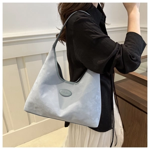 Detail of light blue hobo shoulder bag with matte finish and oval logo plaque