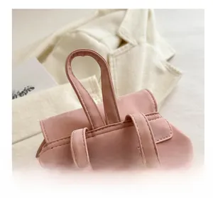 Close-up of pink bucket bag handle and straps with precise stitching on matte fabric