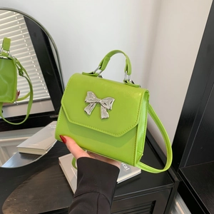 Neon green mini crossbody bag with a silver bow accent and versatile carrying handles