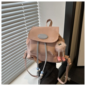 Pink mini backpack with blue drawstring details and a soft plush pendant charm