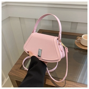 Close-up of pink crossbody bag with silver buckle and adjustable shoulder strap detail