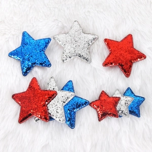 Independence Day sequined star hair clips in red, silver, and blue on white plush