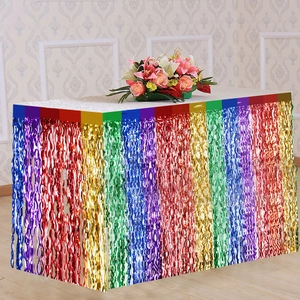 Close-up of vibrant rainbow metallic fringe table skirt for unicorn party decorations