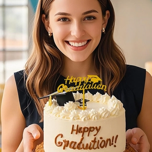 Detail of golden Happy Graduation cake topper with mini black mortarboard cap decoration