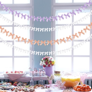 Handmade ribbon bow garland in purple, white, and pink for party wall decoration