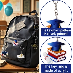 Acrylic graduation keychain with 2025 cap and scroll charms hanging on a black backpack