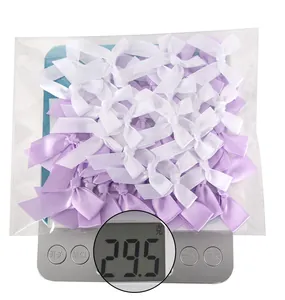 Detailed view of white and purple satin bows weighed on a scale for DIY gift wrapping