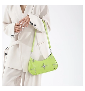 Détail du sac baguette vert vif avec emblème étoile argentée et rivets métalliques décoratifs