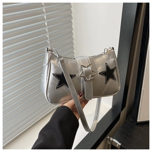 Detail of silver metallic shoulder bag featuring black star appliques and star-shaped buckle