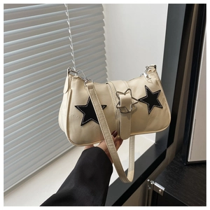 Detail of off-white faux leather handbag featuring black star stitching and metal buckle