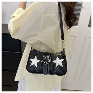Detail of black and white shoulder bag featuring star patches and metal star buckle