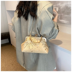 Dettaglio della pochette in raso champagne con paillettes a stella su un abito