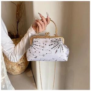 Dettaglio elegante borsa da sera in raso crema con paillettes e cornice in metallo oro