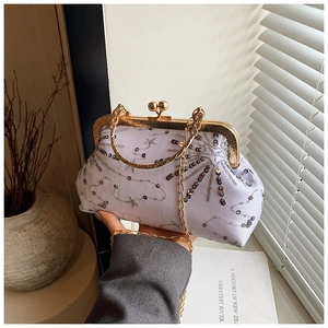 Dettaglio ricamo di paillettes su borsa vintage con chiusura a scatto e catenella