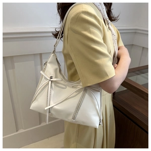 Dettaglio borsa a spalla bianca con decorazione a fiocco e particolari zip eleganti