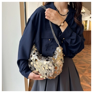 Close-up of sparkling sequin crescent bag with metallic silver chain shoulder strap