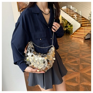 Close-up of a sparkling hobo bag with gold and silver sequins and a fine metal chain