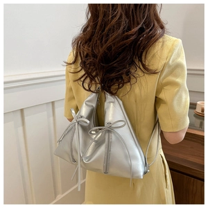 Silver metallic backpack with geometric design and ribbon detail shown on model back