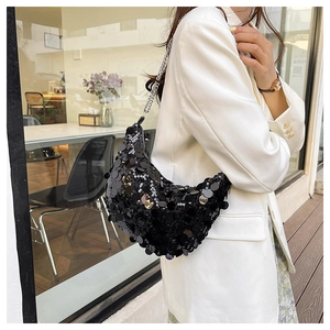 Detail of black sequin saddle bag with silver chain strap and polished finish