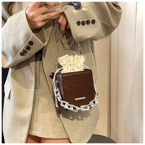 Detail of brown leather bucket bag with silver chain and rabbit embossed pattern